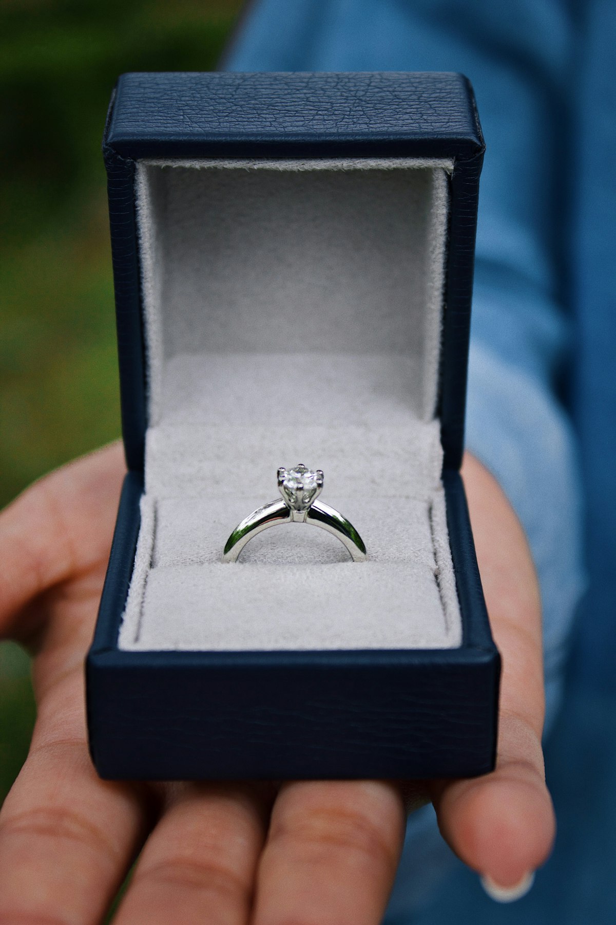 A solitaire diamond engagement ring presented in an open ring box