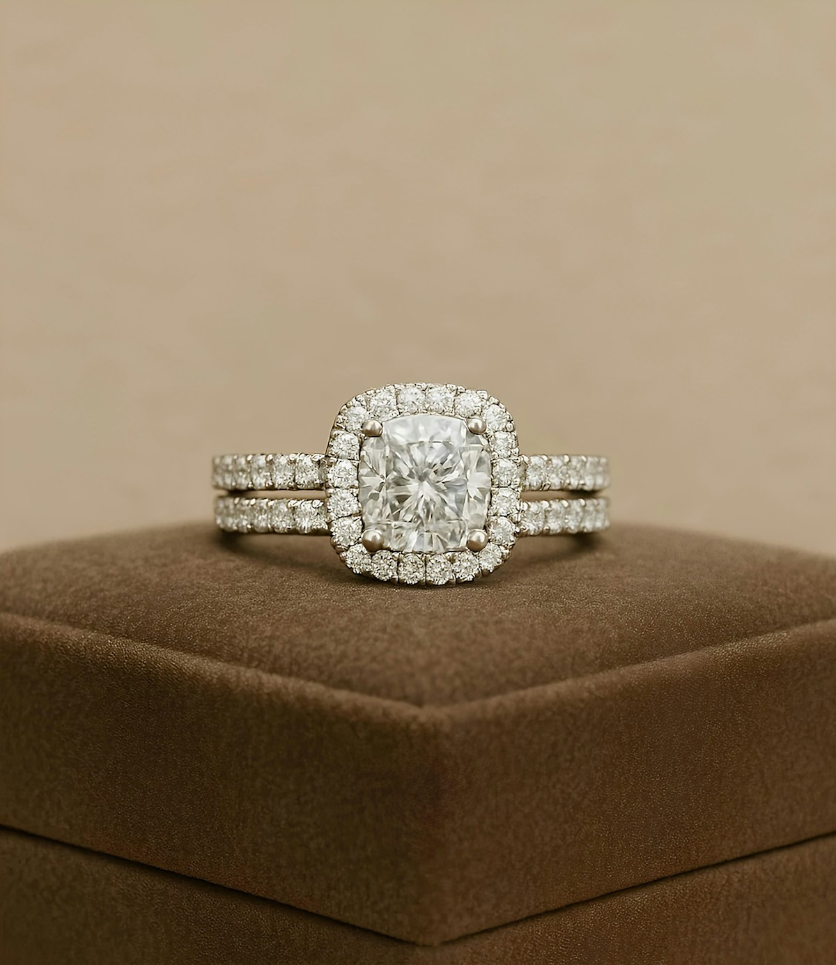 A cushion cut halo engagement ring set on a velvet box