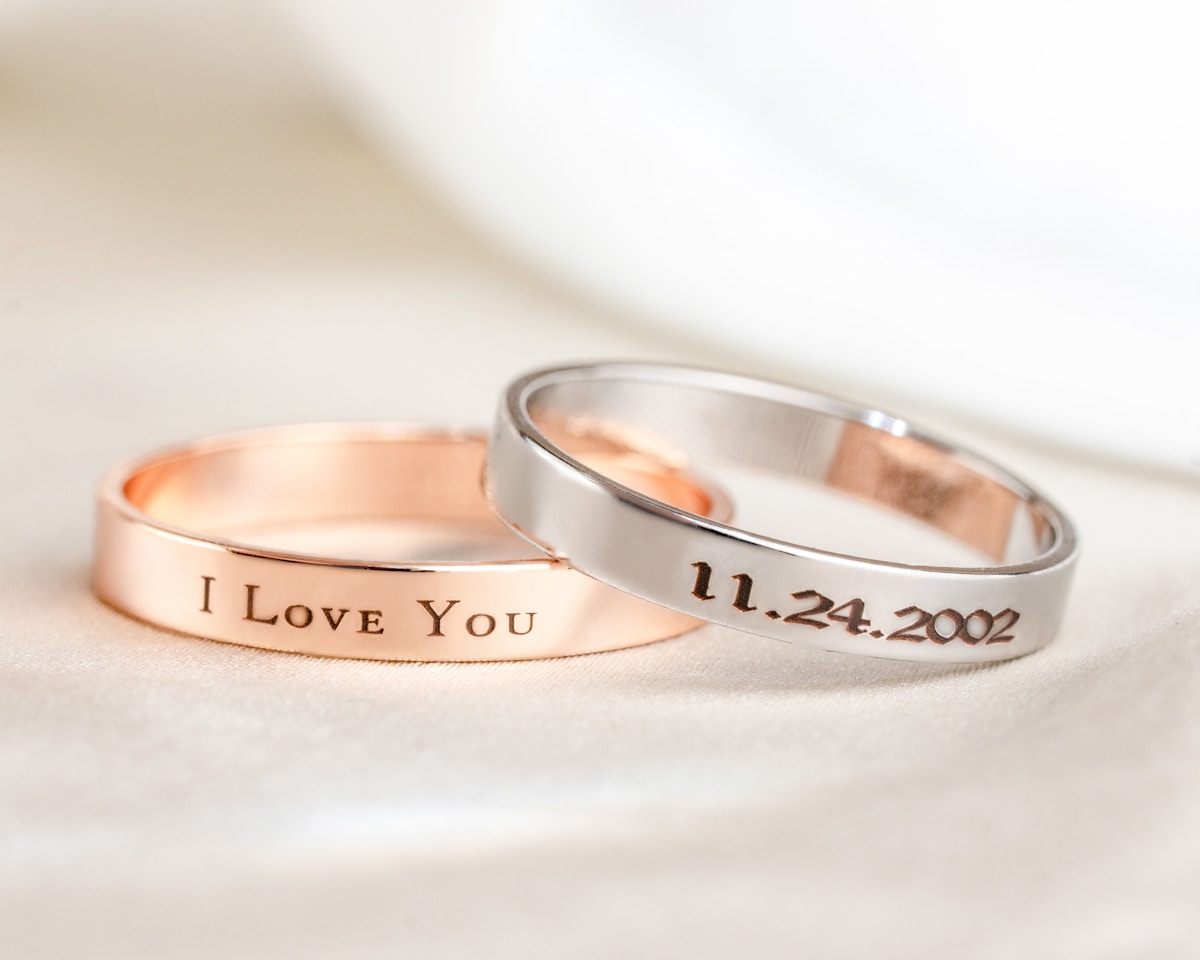 Two wedding bands with engraved text — 'I Love You' and a date