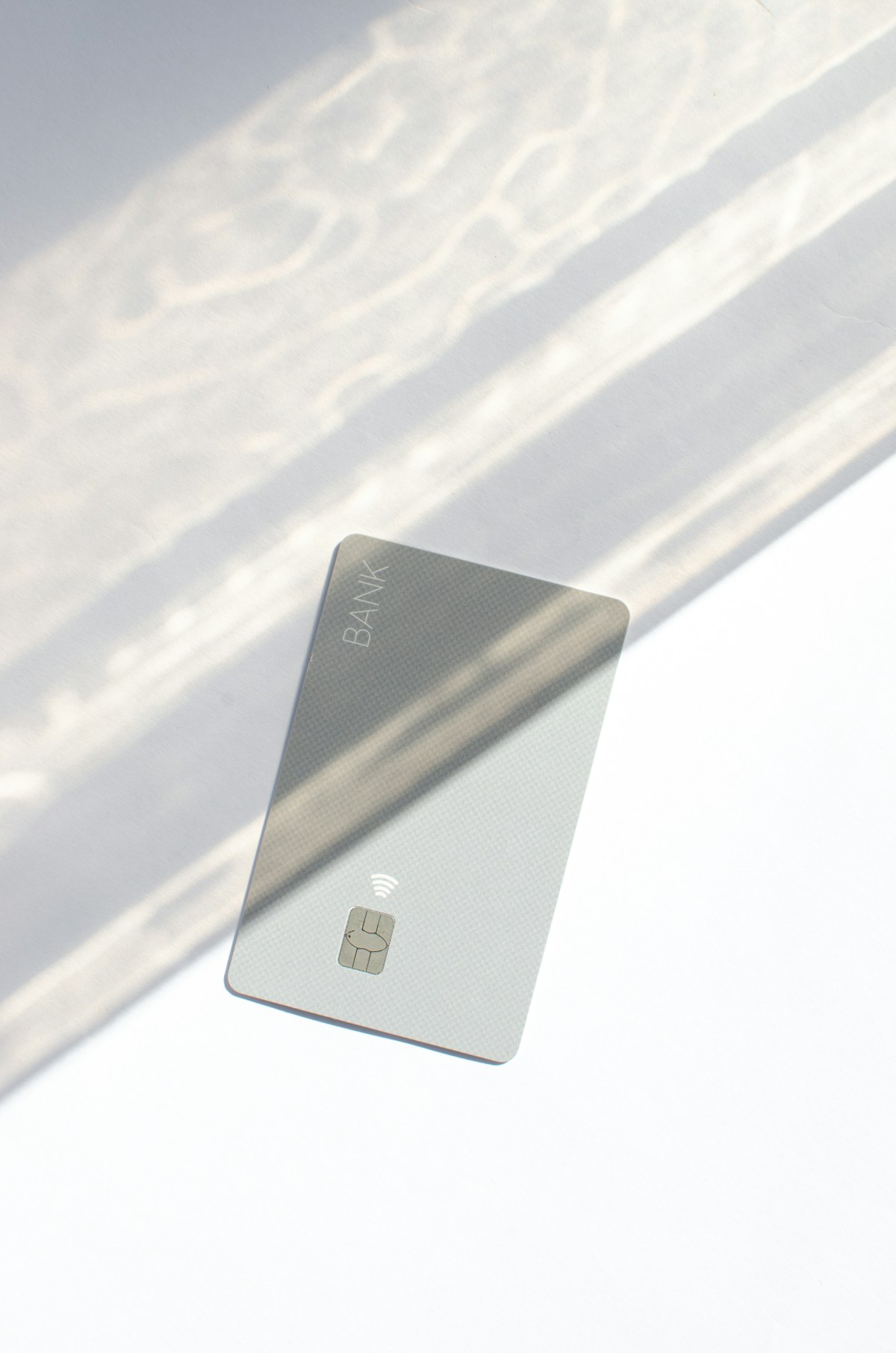 A minimalist bank card catching dramatic natural light
