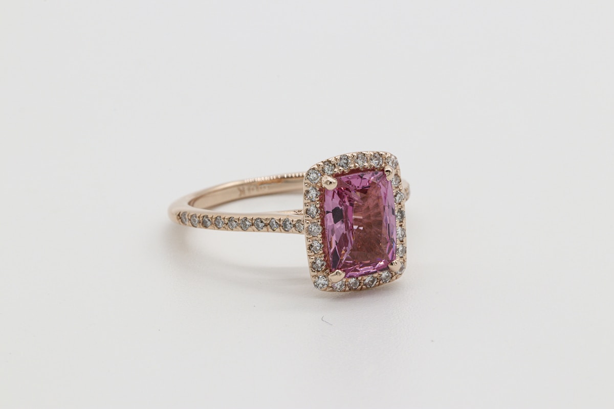 A pink sapphire halo engagement ring in rose gold