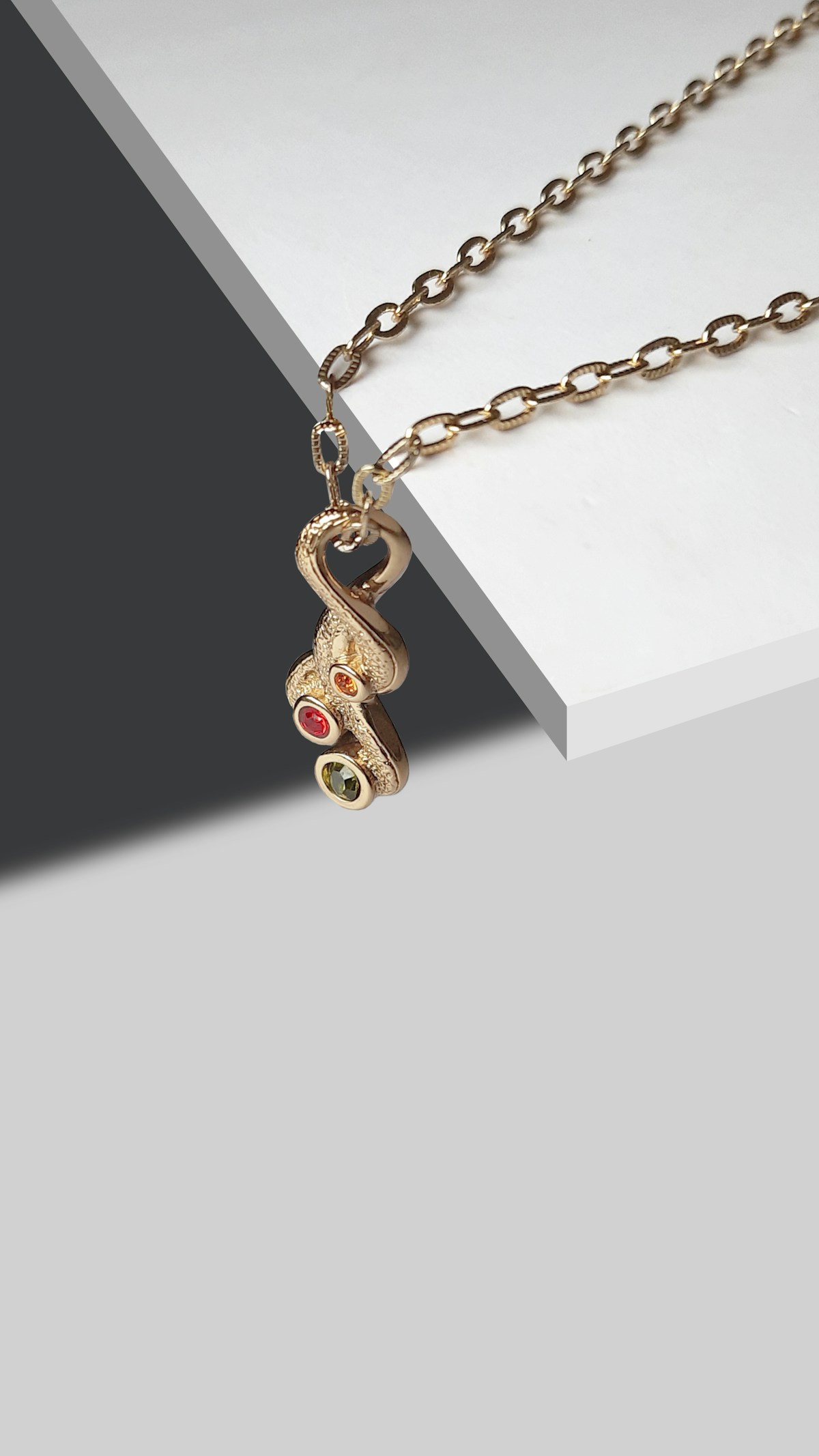 Gold pendant set with multiple colored birthstones on a chain