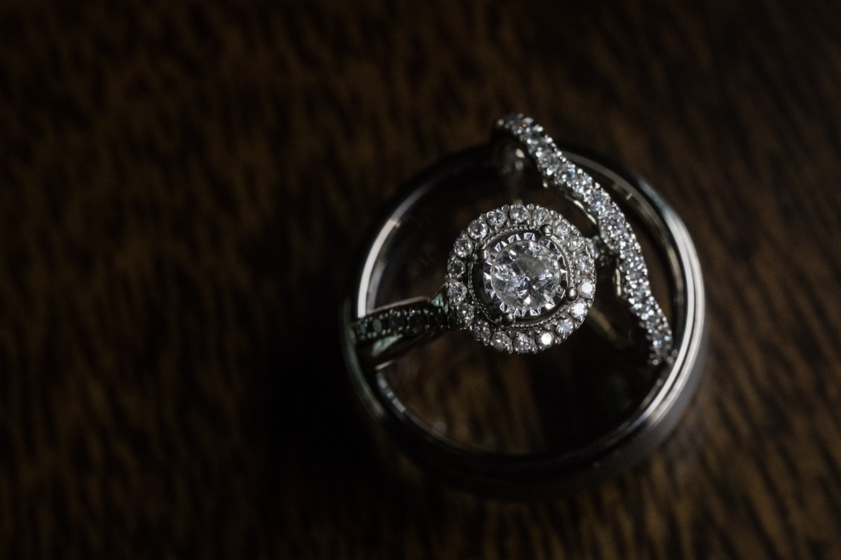 A halo diamond ring nested inside a band, top-down view on a wood surface