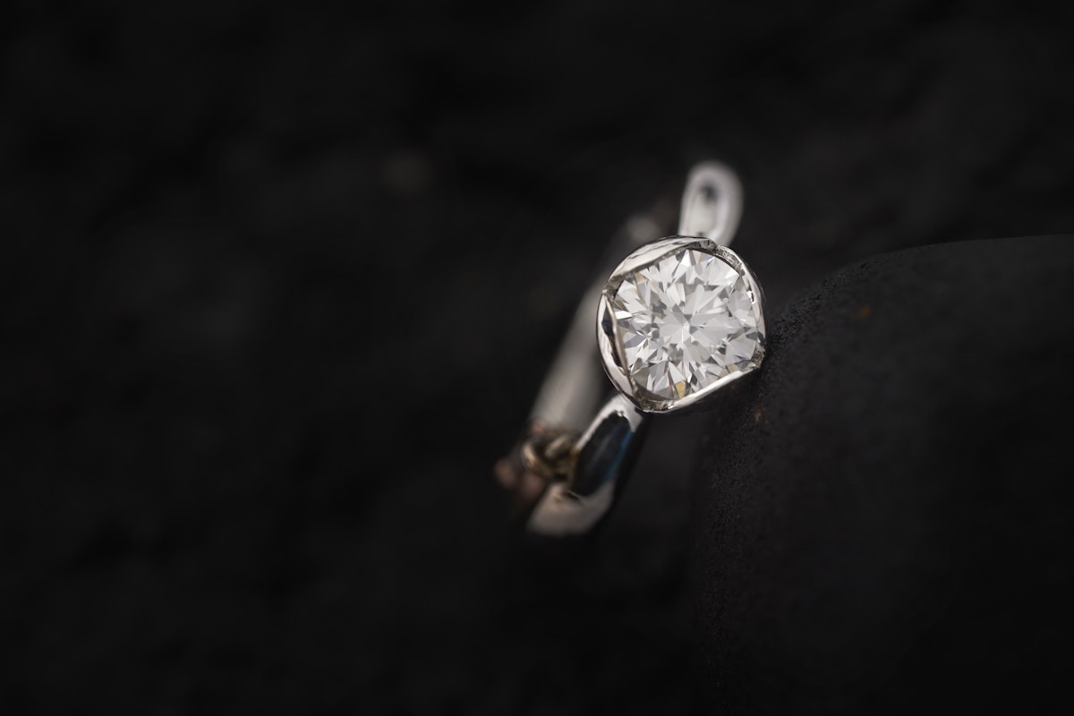 A diamond appearing to float in a tension-set ring against a dark background
